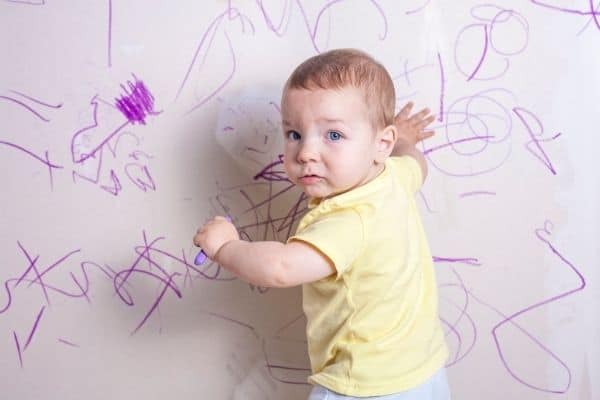 kid scribbling on wall